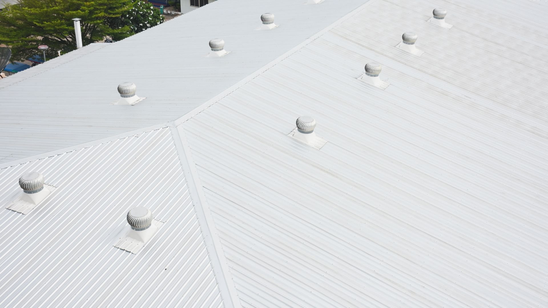 White roof with multiple ventilation turbines and diagonal textured panels