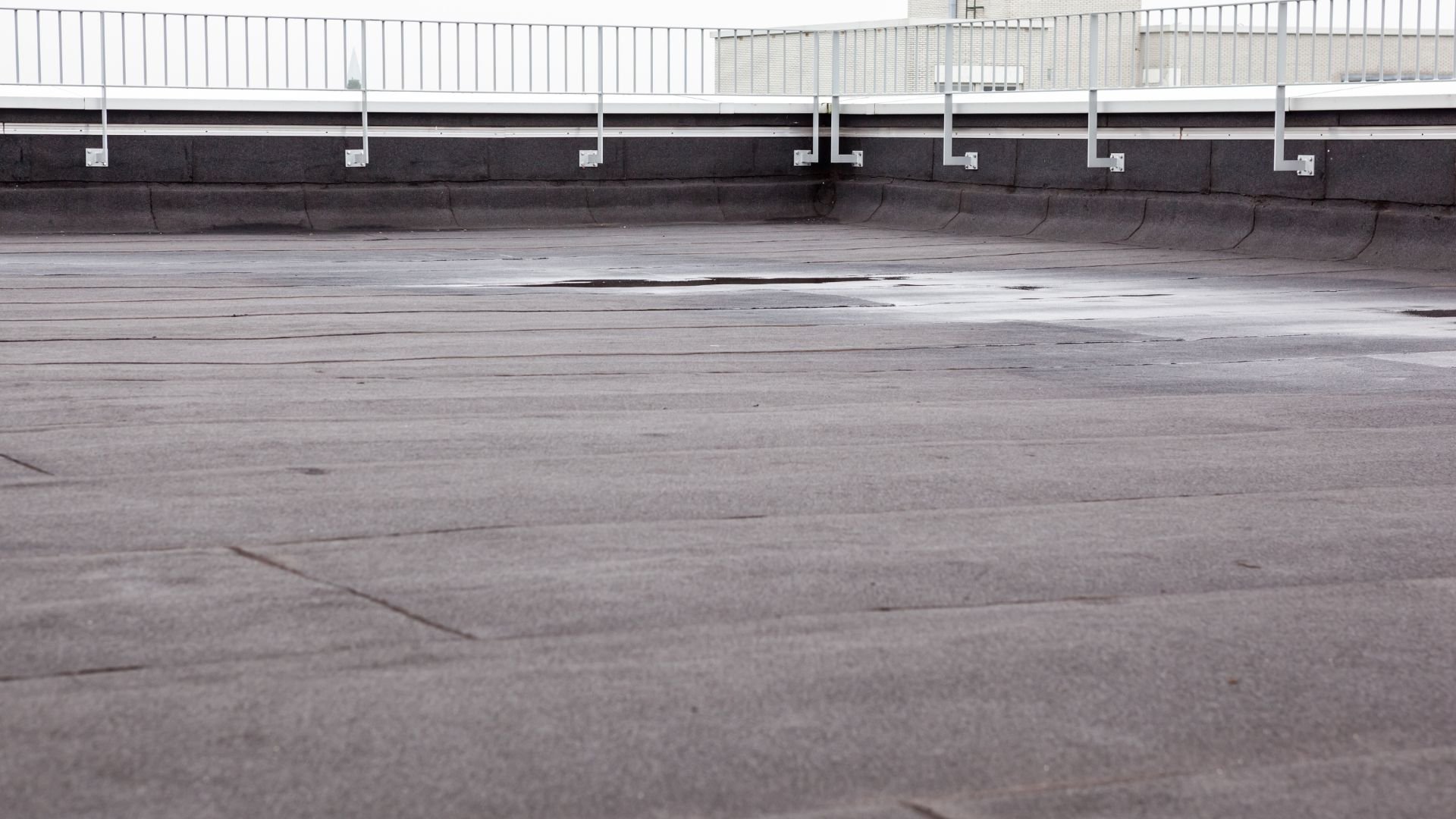 Empty rooftop with gray surface and white metal railing