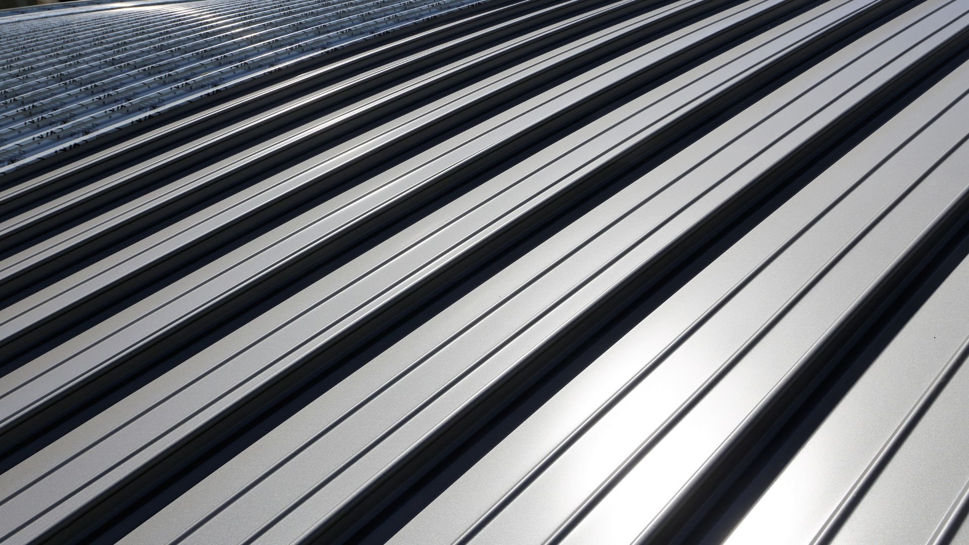 Close-up of metallic roofing with silver and black parallel lines