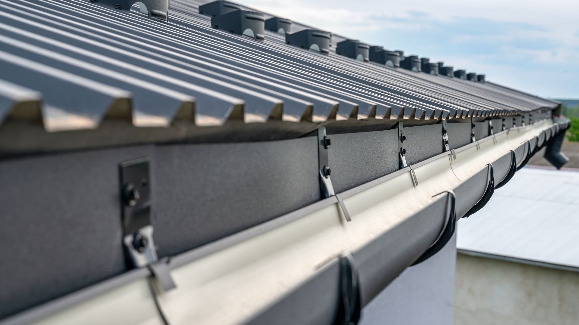 Close-up of modern metal roof with gutters and geometric architectural details
