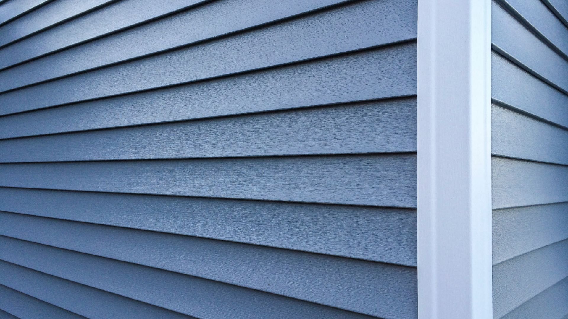 Blue-gray horizontal siding on exterior of building with vertical corner trim